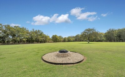 Outdoor firepit in this 4-bedroom- 4-bathroom historical home with guest house on 3 acres of land in the greater Waco area.