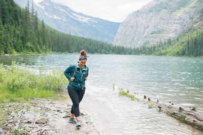 Christy hiking near a beautiful lake and mountains.