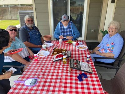Residents sitting together having a picnic in the yard at creekstone senior living in Kennewick, Washington