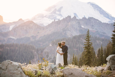 Pregnant couple kissing in the mountains at Mount Rainier National Park