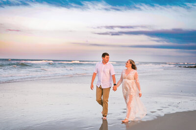 A SUNSET ENGAGEMENT SESSION AT THE BEACH IN ST. AUGUSTINE FLORIDA WITH THE COUPLE WALKING.