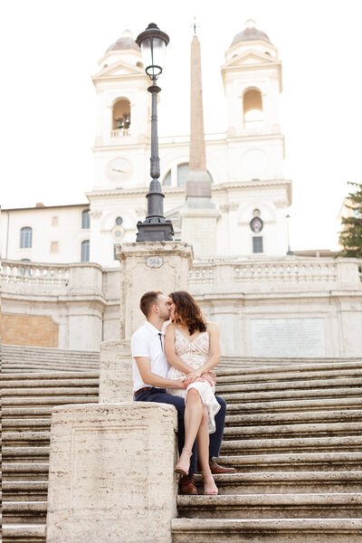 Couple sitting on the Spanish Steps kissing. Taken by Rome Photographer, Tricia Anne Photography.