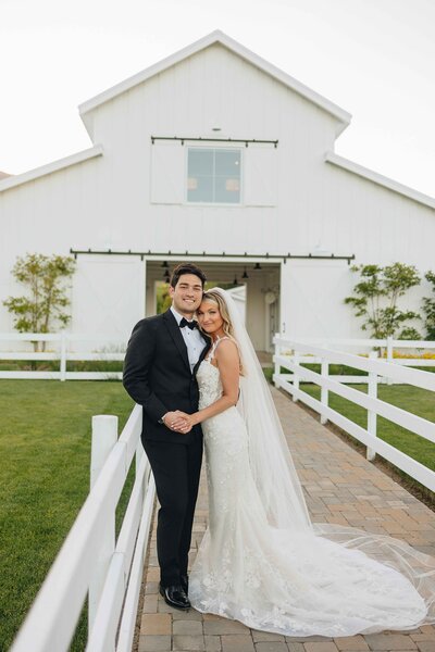 Couple Posing in Front of Lux White Barn - Mikayla & Mario | Harmony Meadows Wedding - Lake Chelan Wedding
