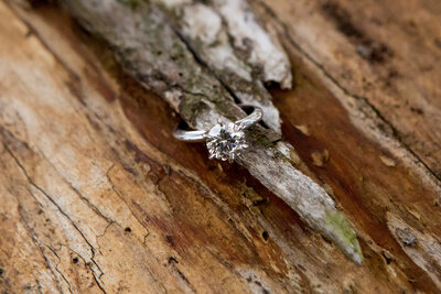 Closeup of a diamond ring on a piece of wood New York engagement photographer Milestone Images