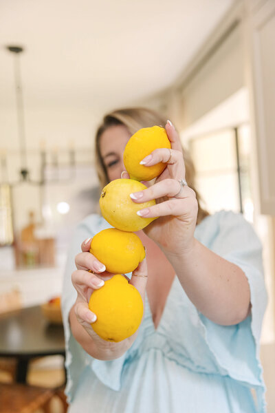 Mollie Mason holding a stack of 4 lemons