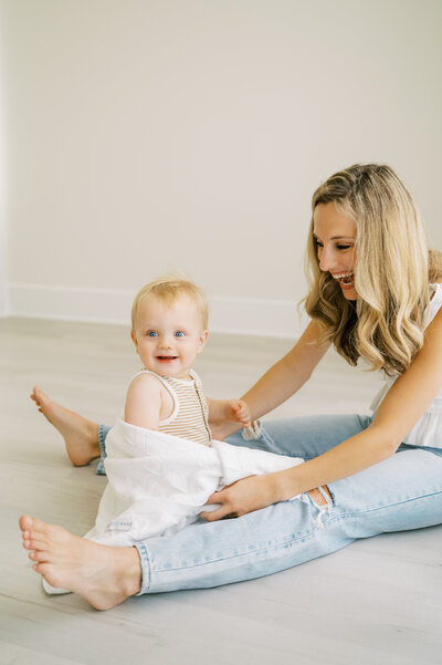 Mom plays on floor with baby in Worth Capturing photo studio in Raleigh NC