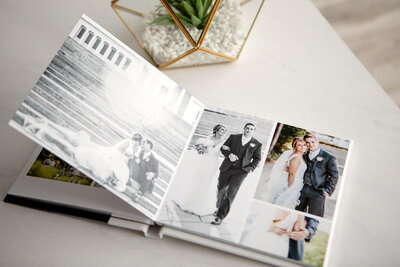 Wedding photo album open on table with cactus terrarium