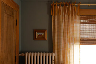 Cozy nursery with old house charm. Vintage art paired with yellow patterned curtain and a nice blue paint color for the walls.