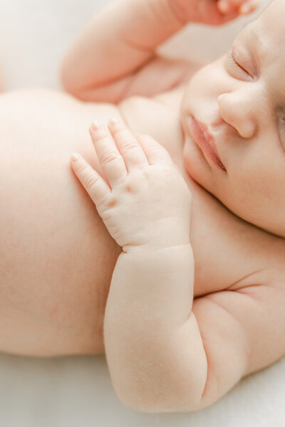 Close up of baby rolls as newborn baby sleeps during newborn photography session