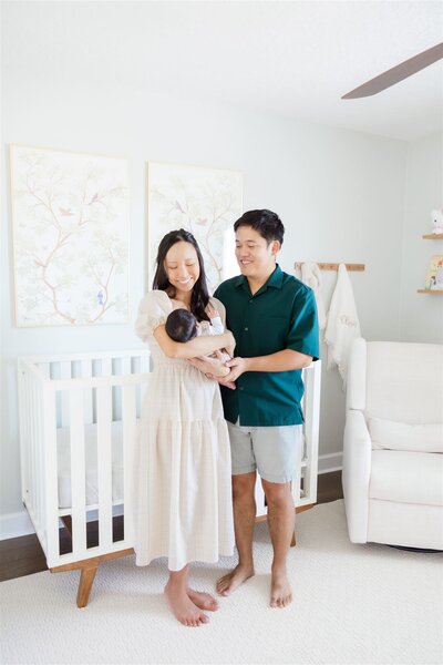 A family photo with a newborn in a nursery in Orlando, Florida by newborn photographer