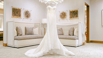 Gorgeous dress hanging from chandelier at the bridal suite promontory club park city utah taken by Cali Warner Media