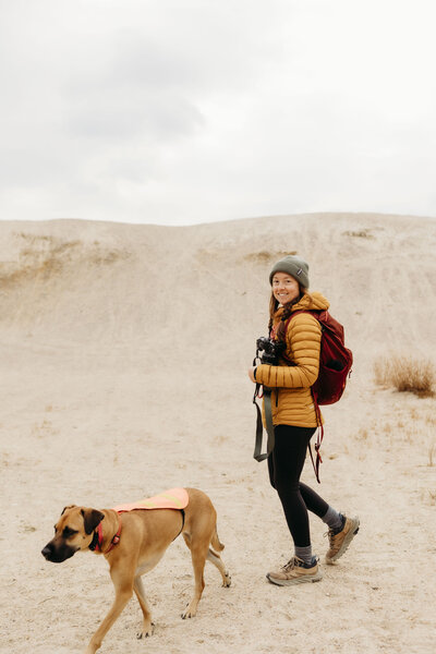 meredith ewenson with her dog winnie walking through the rhode island desert sandy hiking trails