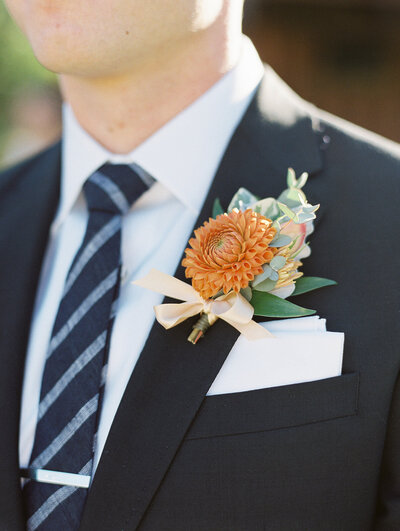 bride with orange floral boutonniere