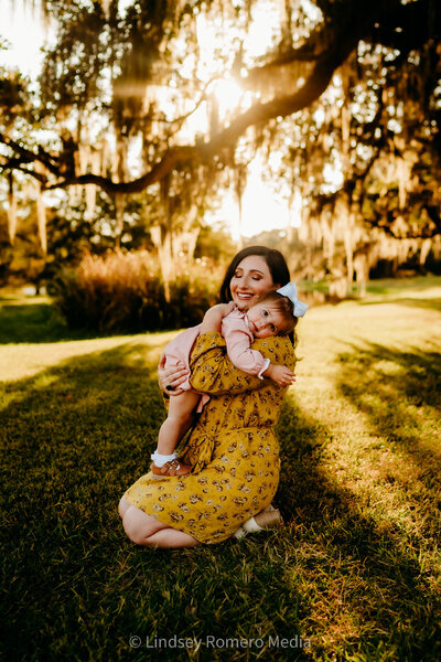 kneeling mommy and me pose with toddler girl at sunset in new Iberia, la