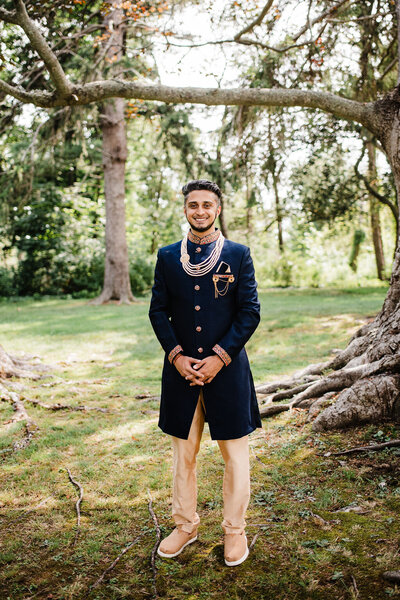 Groom standing outside dressed for wedding, Blended wedding at Peirce Farm at Witch Hill