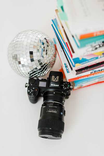 nikon camera with disco ball and stack of books
