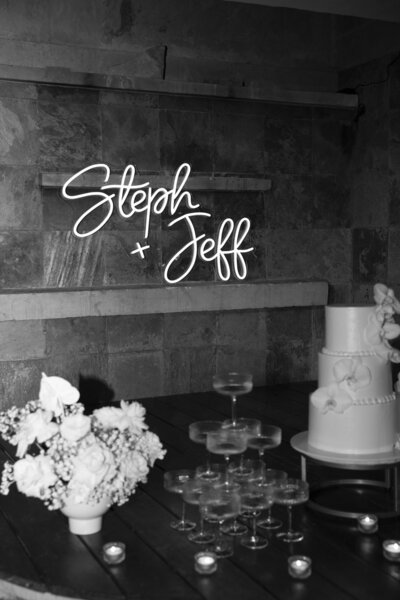 A stunning black and white photo capturing a wedding cake adorned with beautiful flowers, expertly captured by an Austin wedding photographer.