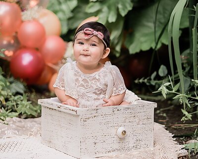 baby girl sitting in box for milestone pictures with ann marshall photography in portland