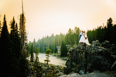 bride and groom kissing on top  rock in Jackson Hole