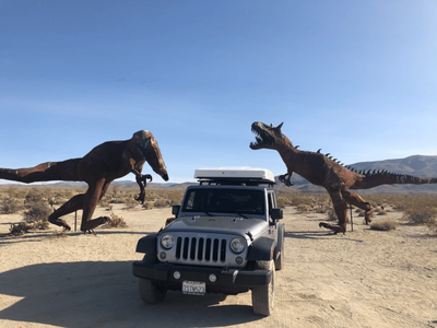 REnted Jeep in desert with dinosaurs