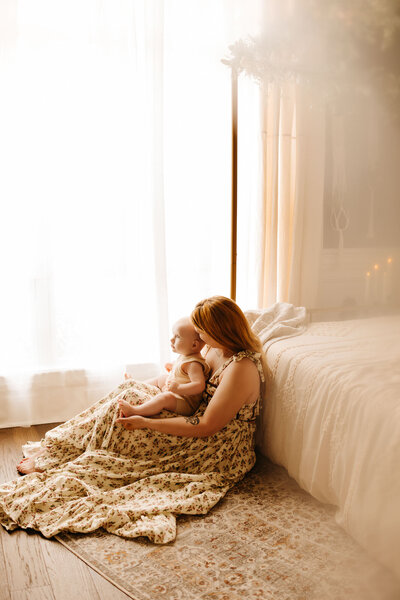 mother sitting with young baby in nursery