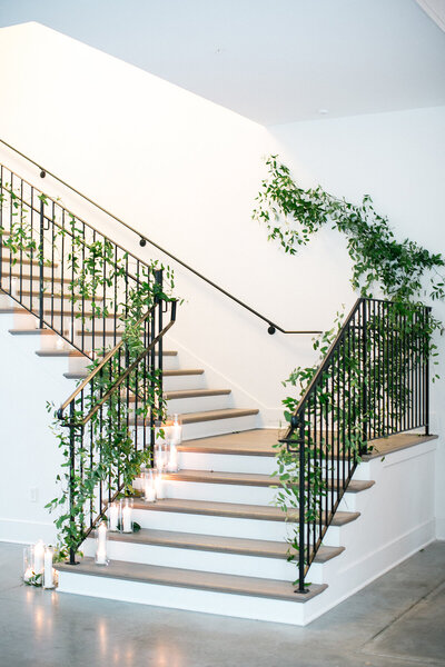 White staircase with fresh green ivy and candles