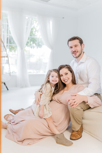 gorgeous family snuggling together inside Roseville CA studio during maternity photoshoot with Bendel Photography