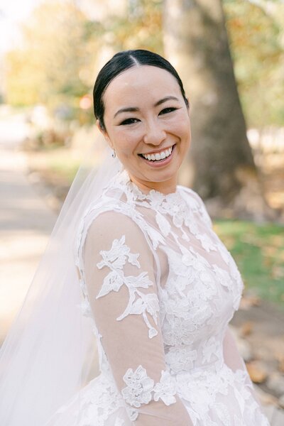 Bride smiling in her Monique Lhuillier lace gown
