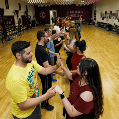 Students of all ages and skill levels come together for an energetic and educational group class at AZ Ballroom Champions, exploring various dance styles in a welcoming environment.