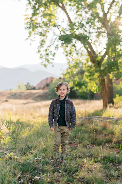 Northern Virginia family photographer takes an image of a cute toddler boy who is wearing a tweed jacket, green shirt and tan pants