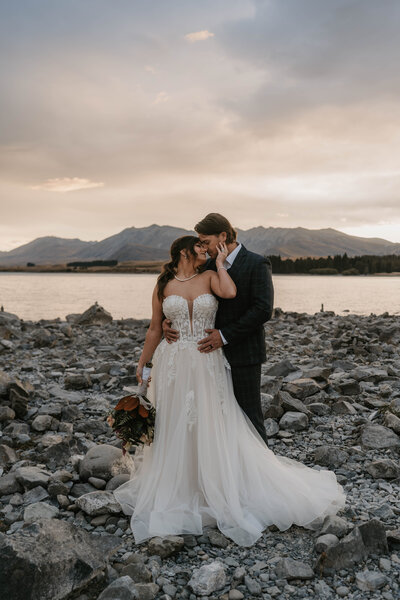 A bride and groom dance under a chandelier in an outdoor pavilion surrounded by trees, capturing real moments during their Colorado wedding day.