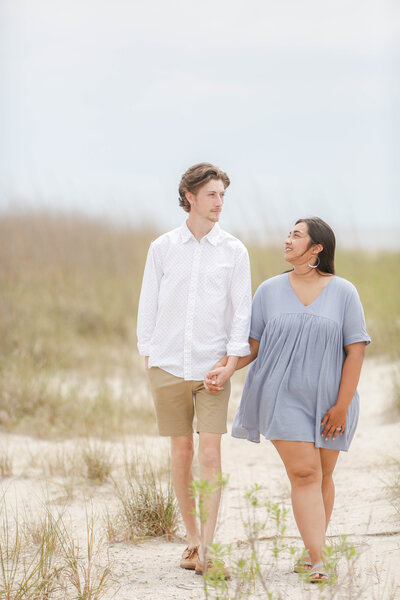 Couple walking hand-in-hand down the Edisto Island beach for family portraits