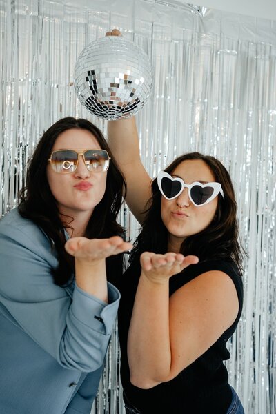 Photobooth pic blowing a kiss and holding a disco ball