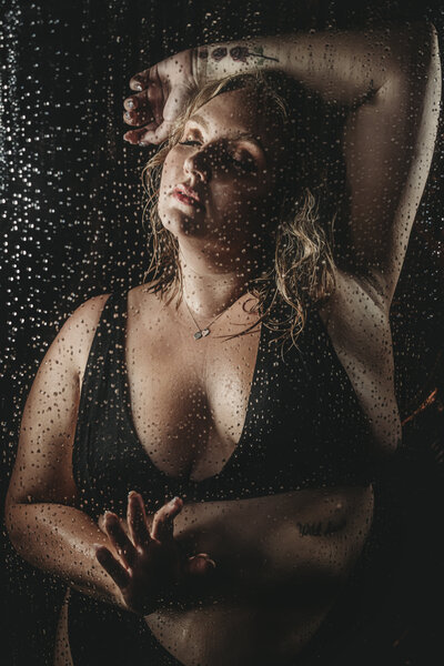 Shower boudoir portrait with water drops with moody lighting in-studio
