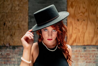 dramatic portrait of woman in pearls and a stetson hat