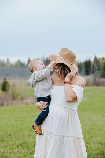 Candid moment of Mom holding young son in an open field in Laporte Minnesota.