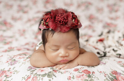 newborn baby girl smiling wearing beige outfit