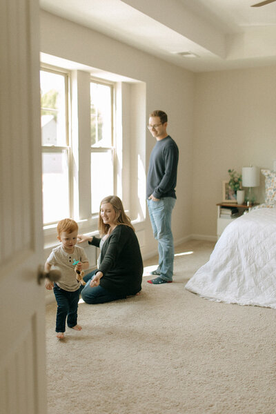 documentary family session in home toddler playing and looking out the window