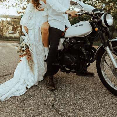 Newly wed couple sitting on motorcycle after their elopement