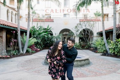 Groom to be surprises his fiance from behind at the Villa del Sol in Fullerton