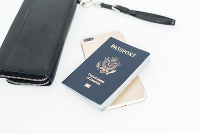 USA passport with gold iphone and a black wallet