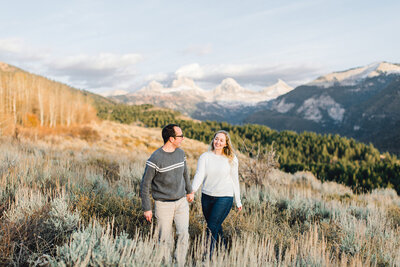 Couple walking in front of Grand Teton Mountains