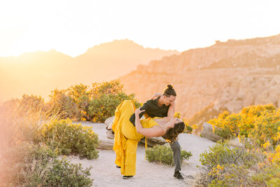 couple dancing on mountain top at sunset