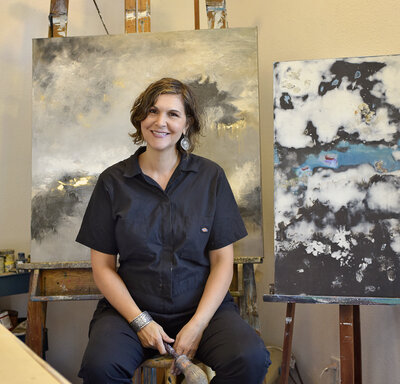 woman smiling with paintings in background