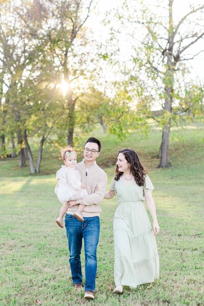 Family walking in a field during golden hour