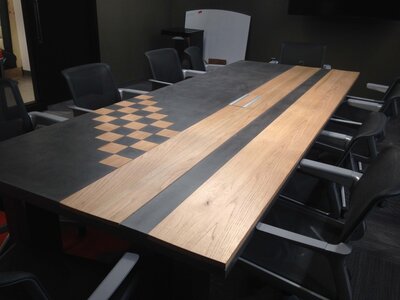 Concrete and wood conference room table with oak and charcoal wood in checkered and striped patterns