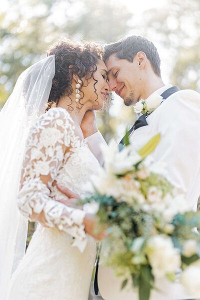 couple in romantic pose under wedding veil