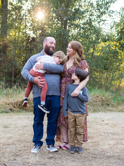 a family is hugging during their family photo session by Becky Langseth Photography, taken at Wallace Swamp Creek Park in Kenmore, WA.