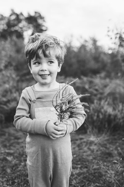 black and white little boy in field nature field