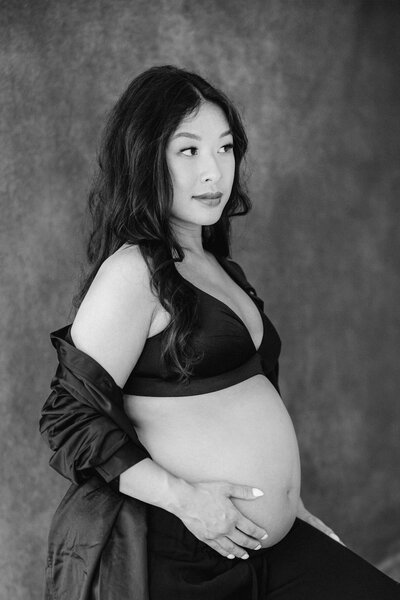 pregnant mom sitting on stool with hand on belly